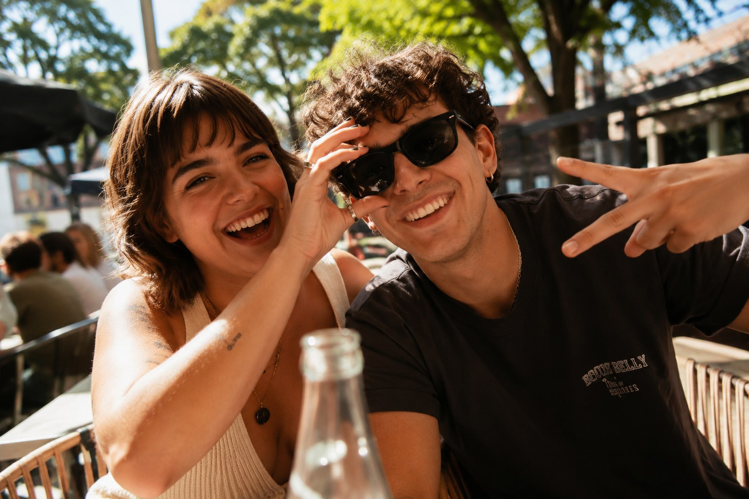Two friends laughing at an outdoor table